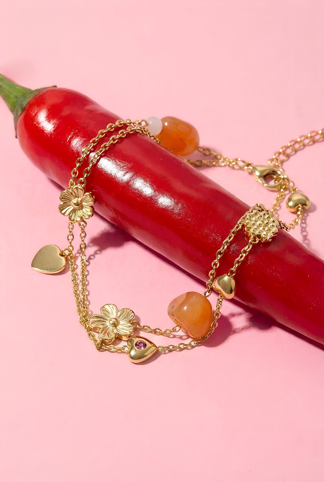 Charm bracelet with orange beads, flowers and hearts